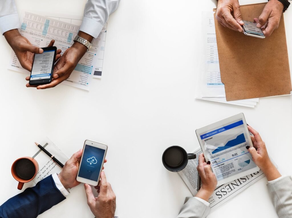 Top View of four people sitting around a desk on their phones